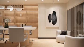Un intérieur moderne comprenant une table de conférence, des chaises, une bibliothèque et une œuvre d’art abstraite accrochée au mur.
