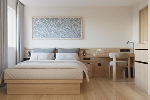 Ein modernes Schlafzimmer mit Bett, Nachttischen, Schreibtisch und Stuhl.
