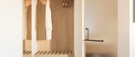 A modern bathroom with wooden cabinetry, a towel rack, and a shower area.