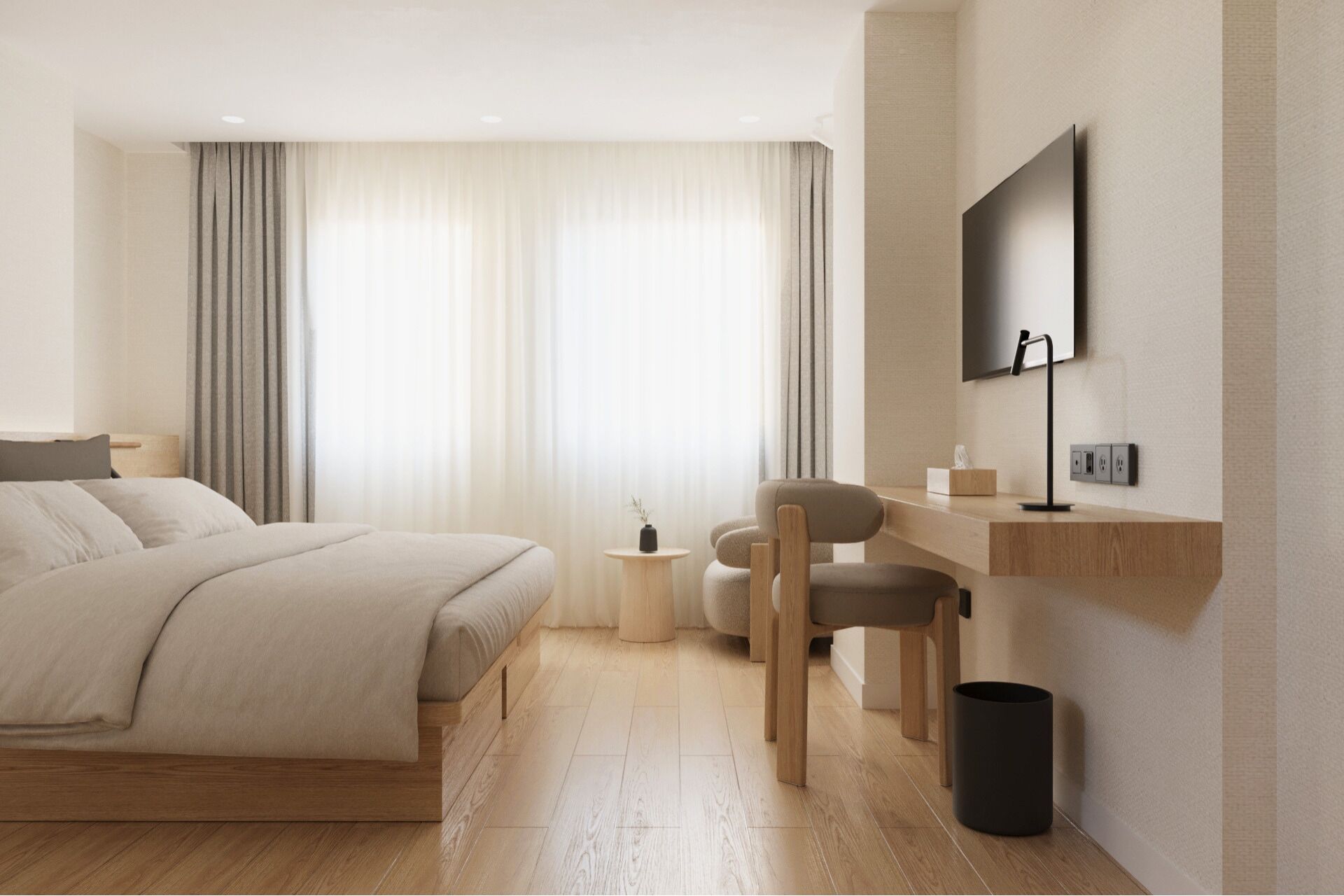 A modern hotel room with a bed, desk, chair, and a flat-screen TV mounted on the wall.