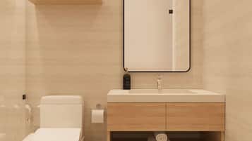 A modern bathroom with a toilet, sink, and mirror.
