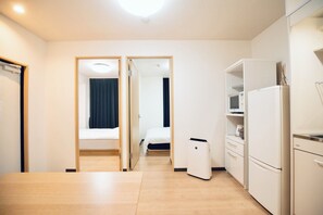 A compact hotel room with a bed, a kitchenette, and a small bathroom. - SERENE Osaka | 5 Minutes from Kuromon Market | 6F-601 | 2-Bedroom · Sleeps 4 (大阪市)