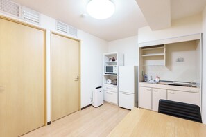 Eine kleine Küche mit einer Mikrowelle, einem Kühlschrank und einem Spülbecken.