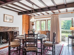 A dining room with a round table, chairs, a fireplace, and a view of the outdoors. - 3 bedroom accommodation in Hawkswick (Hawkswick)
