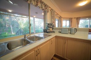 A kitchen with a double sink, a coffee machine, and a toaster.