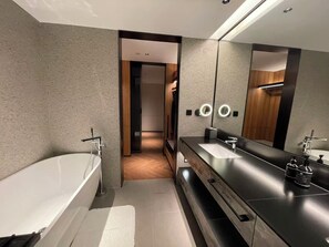 A modern bathroom with a large mirror, two sinks, and a bathtub. - Nester Finn Suites Entertainment Toronto (Toronto)