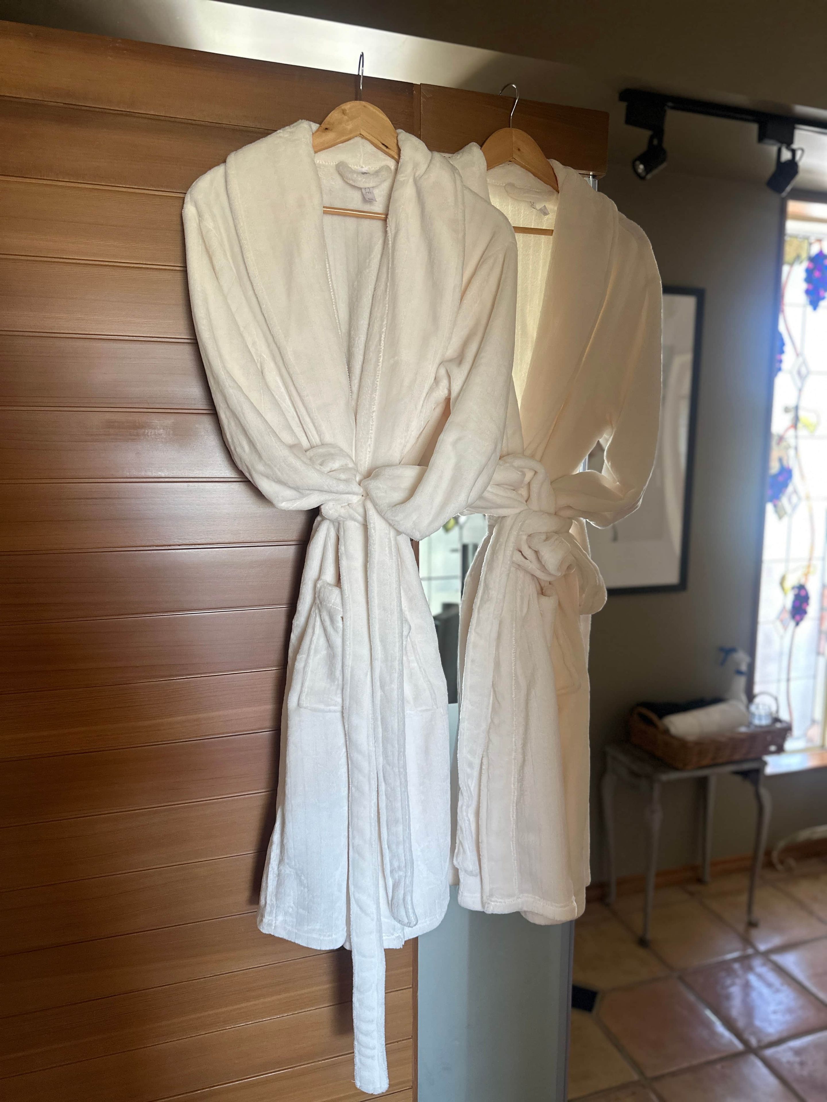 A wooden wall with a rack holding white robes.