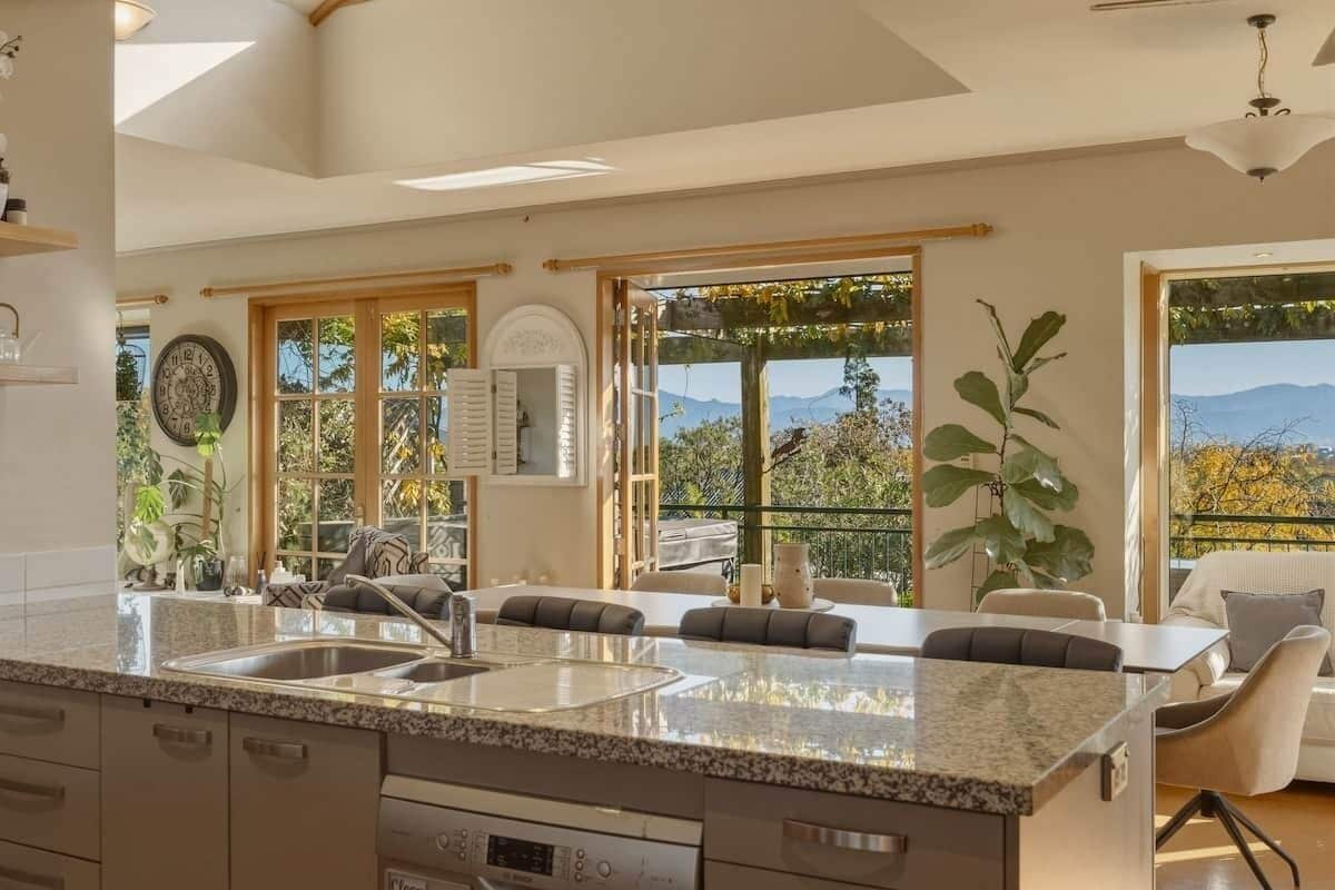 Una cocina con encimera de granito, horno integrado y vistas al exterior.