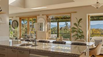 Una cocina con encimera de granito, horno integrado y vistas al exterior.