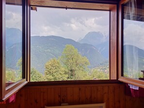 Um quarto com uma janela grande com vista para uma paisagem montanhosa.