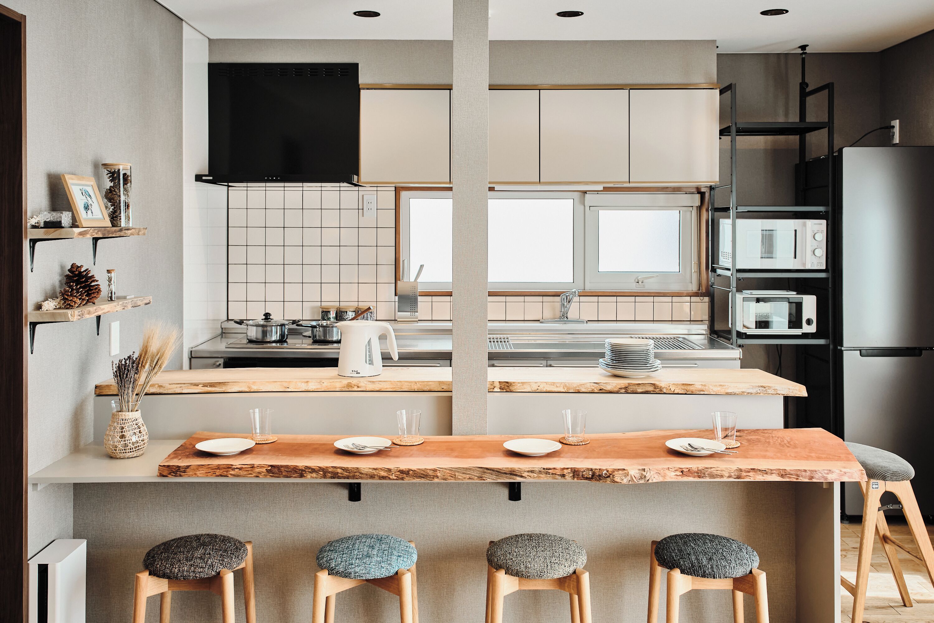 A modern kitchen with a central island, built-in appliances, and a dining area with stools.
