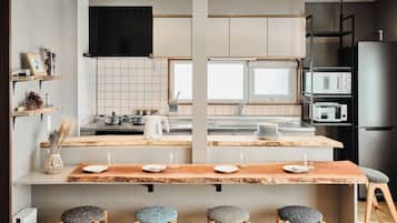 A modern kitchen with a central island, built-in appliances, and a dining area with stools.