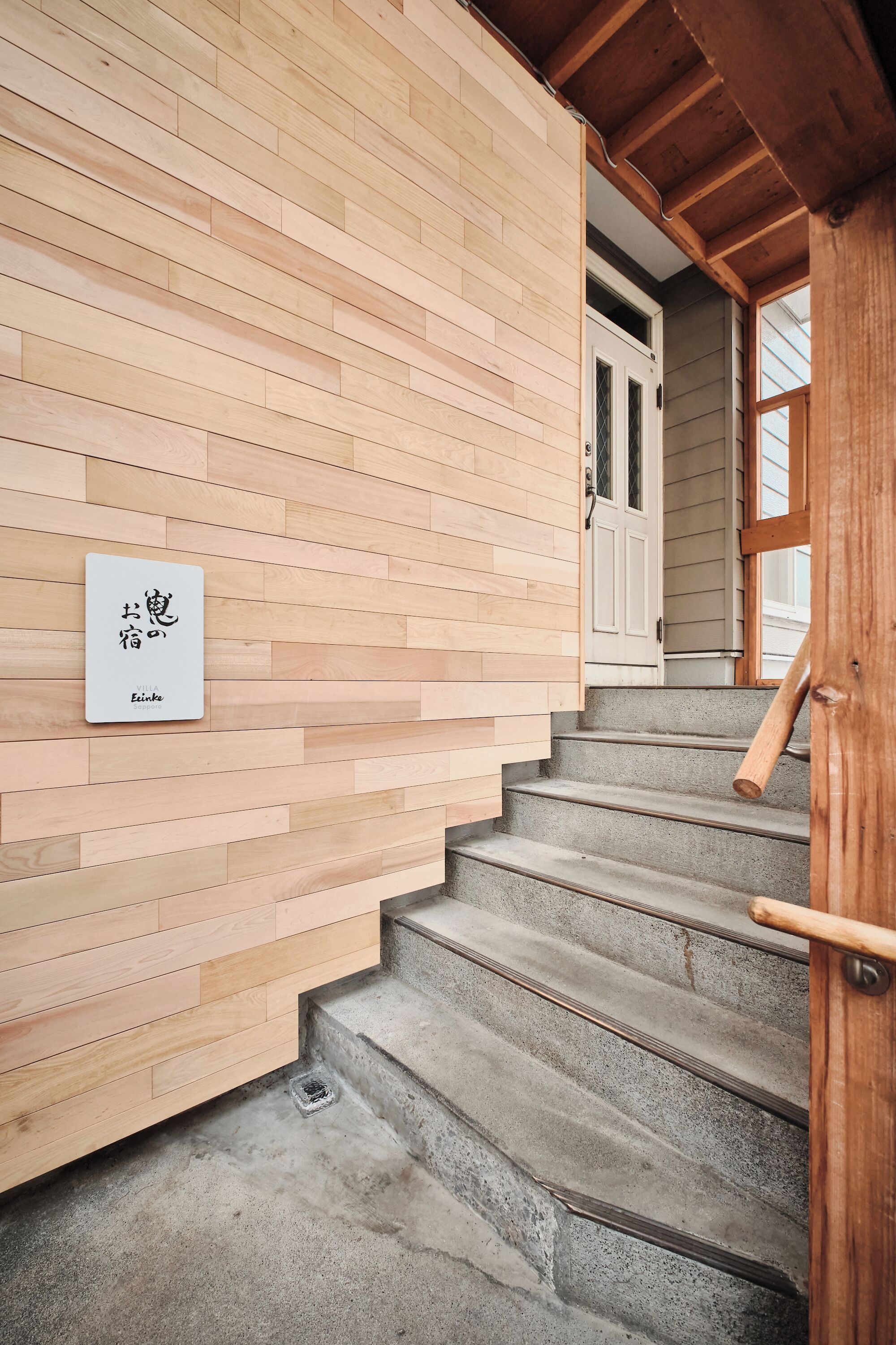 A wooden staircase with a sign on the wall.