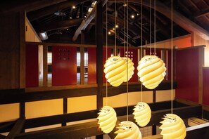 Um interior moderno com luminárias espiral pendentes e estrutura de teto em madeira.