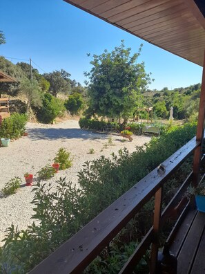 A covered outdoor area with a gravel ground, wooden benches, and potted plants. - Tranquil Chalet Retreat With Shared Pool in Estói, Portugal (Faro)