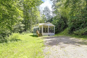 A small, single-story cabin with a porch, surrounded by dense forest. - Relax in Style - Serene Getaway Near Mountain City (Mountain City)