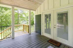 A covered porch with a wooden railing, a door with a security screen, and a doormat. - Relax in Style - Serene Getaway Near Mountain City (Mountain City)