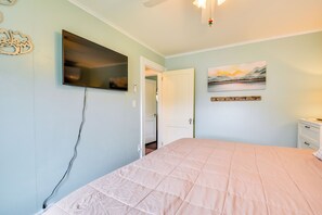 A bedroom with a bed, a television mounted on the wall, a door leading to another room, and a painting on the wall. - Walk to Dtwn Clayton & River! 2-Unit Getaway (Clayton)
