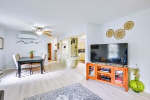 A modern living room with a dining area, a TV, and a green vase. - Walk to Dtwn Clayton & River! 2-Unit Getaway (Clayton)