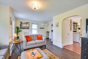 A living room with a sofa, a coffee table, and a dining area with a table and chairs. - Walk to Dtwn Clayton & River! 2-Unit Getaway (Clayton)