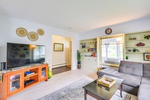 A living room with a flat-screen TV, wooden entertainment unit, grey sofa, and a coffee table. - Walk to Dtwn Clayton & River! 2-Unit Getaway (Clayton)