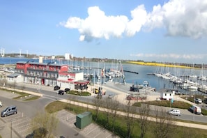 A marina with boats, a red building, and a clear sky. - Apartment Fehmarn-Burgtiefe (Fehmarn OT Burgtiefe-Südstrand)
