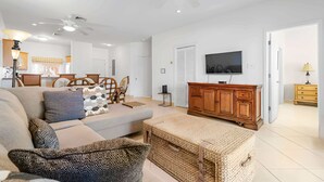 Uma sala de estar moderna com sofá, televisão e um armário de madeira.
