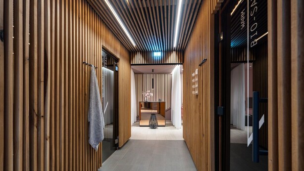 A corridor with wooden paneling, a reception desk, and a sign reading 'BIO-SAN.' - Deluxe Baltic Stay für 6 Personen (Travemünde)