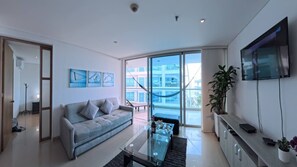 A modern living room with a sofa, coffee table, and a TV mounted on the wall. - Beautifull Condo Apartament with sea view Morros Sonesta (Cartagena)