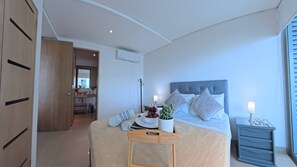A bedroom with a bed, bedside table, and a view of a bathroom. - Beautifull Condo Apartament with sea view Morros Sonesta (Cartagena)
