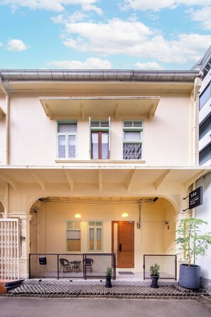 A two-story building with a balcony, a wooden door, and a sign indicating 'Heritage House'. - Spacious Heritage House Prime Location Family Stay (Khet Bang Rak)