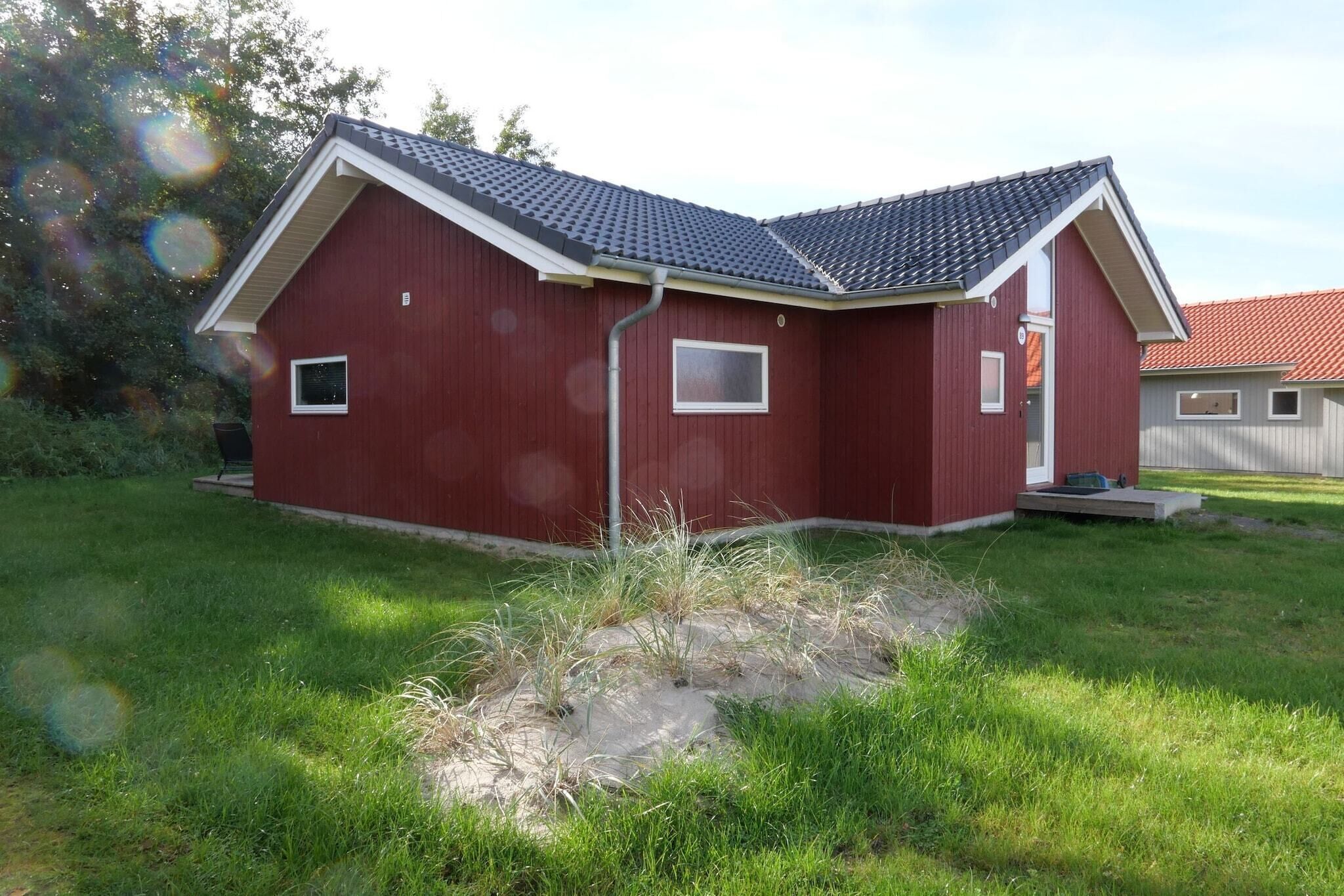 A red building with a sloped roof, a small window, and a door.