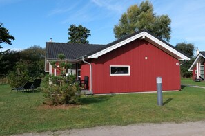Un bâtiment rouge avec un toit en pente, un petit porche et une fenêtre.