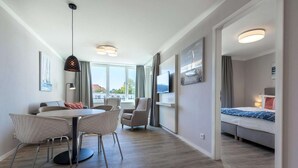 A modern hotel room with a dining area, a bed, and a TV. - Apartment in Strand- und Parknähe (Travemünde)