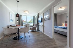 A modern hotel room with a dining area, a bed, and a TV. - Apartment in Strand- und Parknähe (Travemünde)