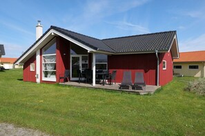 A red building with a covered patio and a chimney. - Spa-Haus in der Nähe von South Beach (Großenbrode)