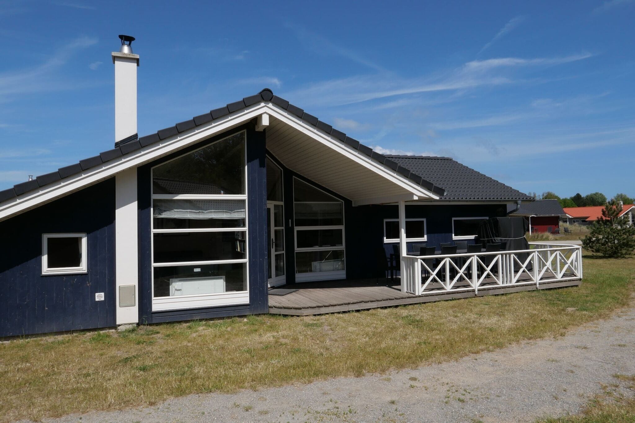 Et moderne hus med stor garage, en overdækket veranda og skorsten.