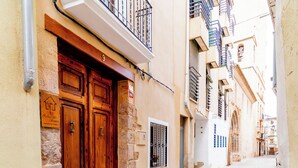 Una estrecha calle adoquinada bordeada por edificios con puertas y balcones de madera.