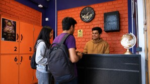 A reception area with orange lockers, a clock, and a globe on a stand.
