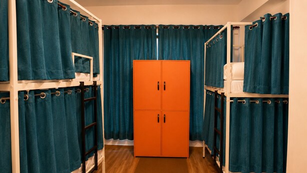 A corridor with teal curtains, wooden flooring, and an orange wardrobe. - Loopin Mcleodganj  (Dharamshala)