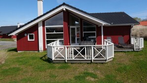 Ein rotes Gebäude mit einer weißen Veranda und einem Schornstein.
