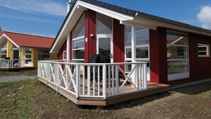 En rød og hvid bygning med balkon og store vinduer.