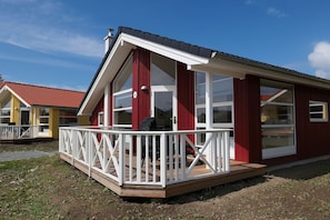 Ein rot-weißes Gebäude mit Balkon und großen Fenstern.