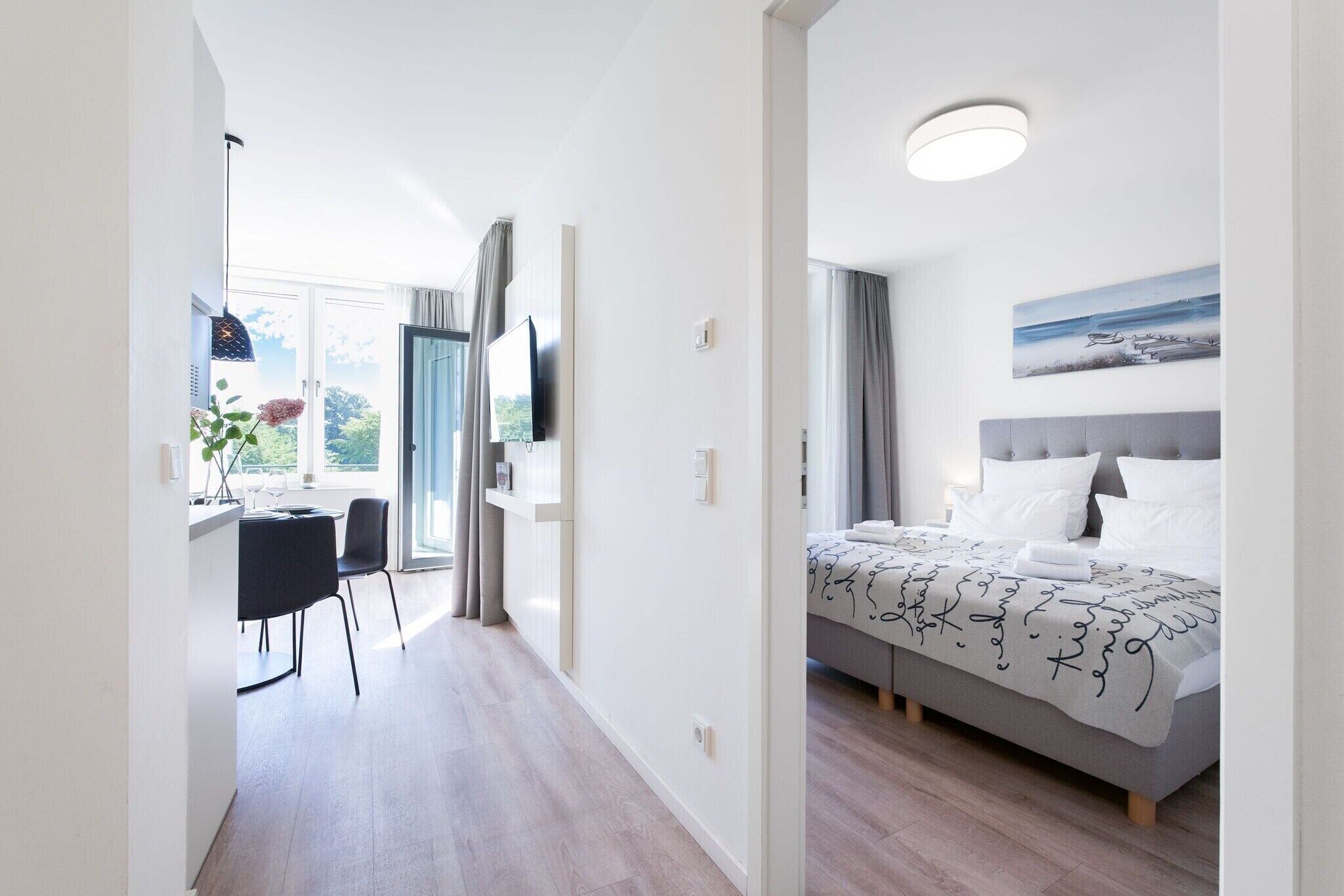 Ein Hotelzimmer mit einem Bett, einem Schreibtisch und Blick ins Freie.