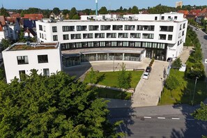 A modern building with a curved facade, a central courtyard, and a parking area. - Apartment near the Baltic Sea (Travemünde)
