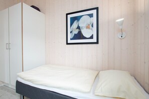 A bedroom with a bed, a wardrobe, and a framed picture on the wall. - Skandinavischer Rückzug für 6 (Großenbrode)