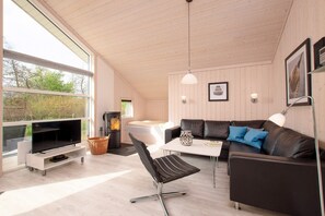 Una sala de estar moderna con televisor, sofá y chimenea.