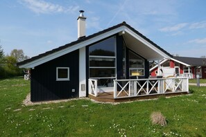 A modern house with a large deck, a chimney, and a spacious interior. - Nordic Spa Lodge für 6 Personen (Großenbrode)