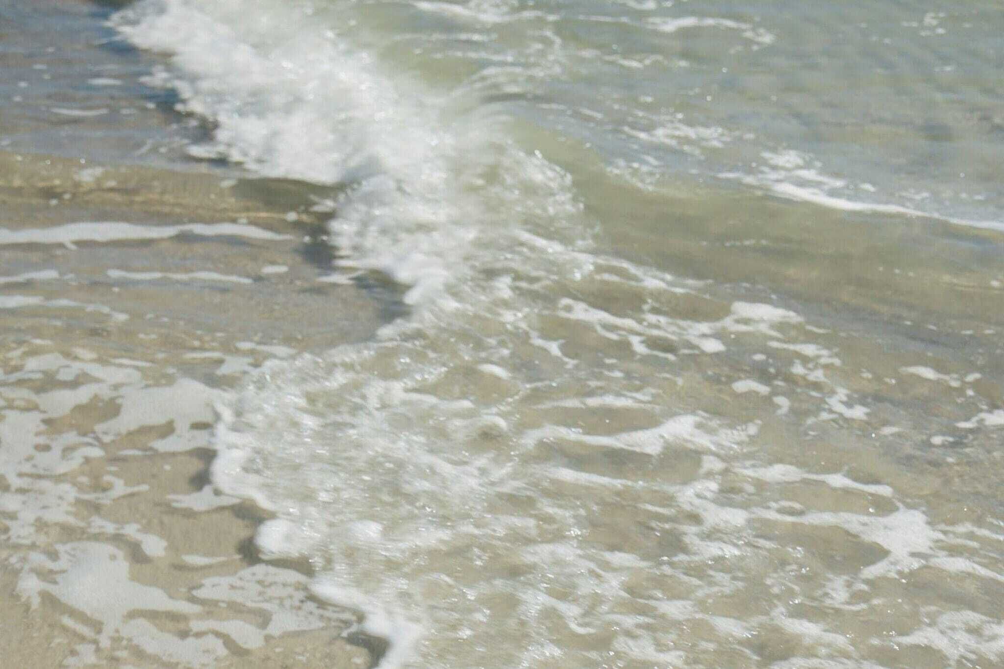 Una playa con olas acercándose a la orilla.