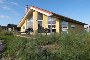A yellow building with a red roof, large windows, and a number '133' on the door. - Ruhiges Küstenretreat für 6 (Großenbrode)
